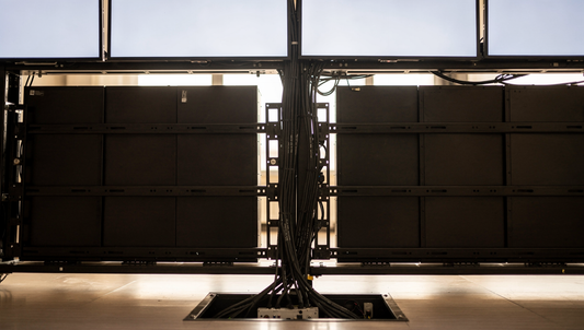 Video wall controller rack feeding a multi-panel display wall in a control room